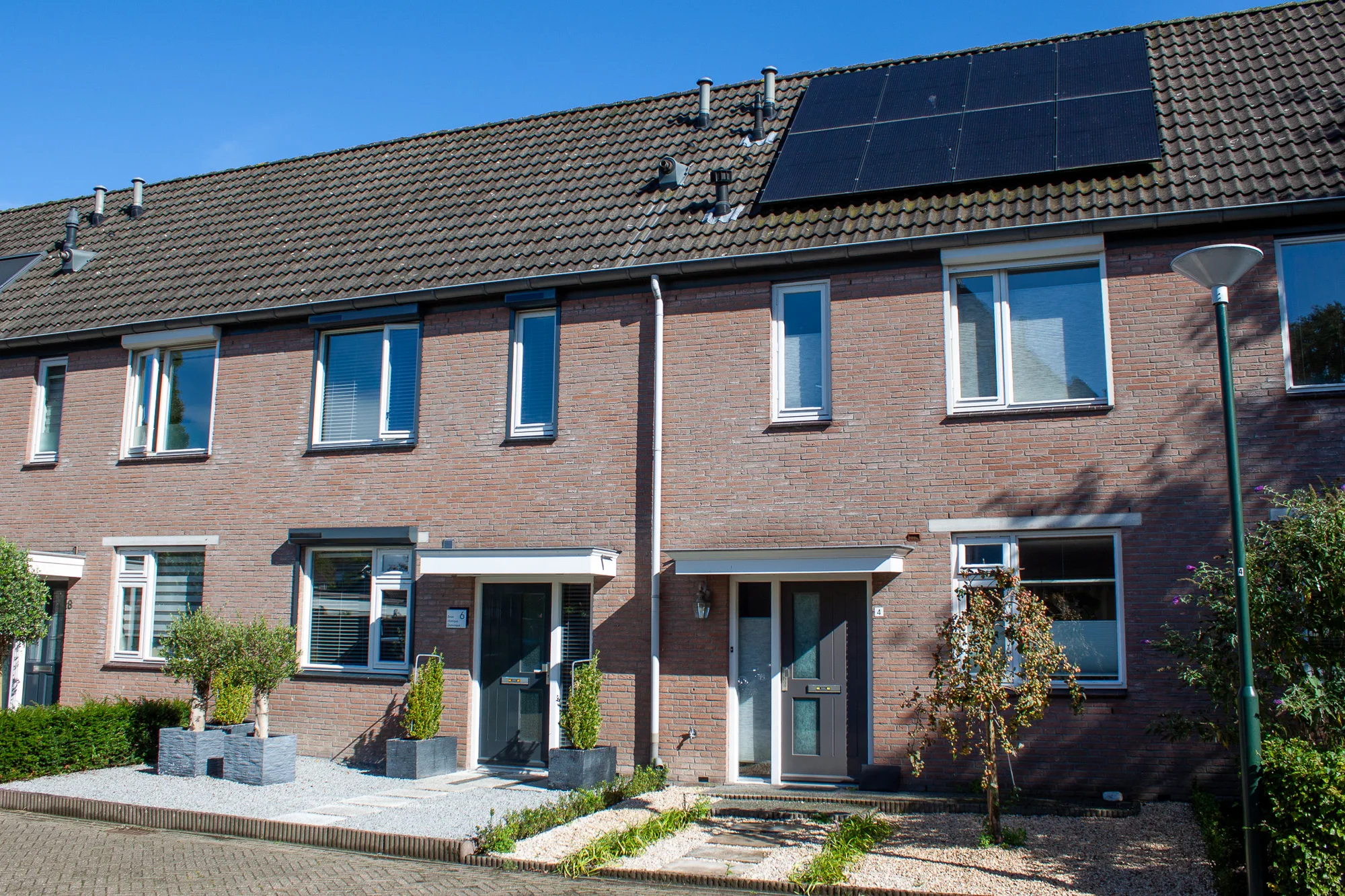 Rij huurwoningen met zonnepanelen op het dak, zoals een woning van Woonbedrijf