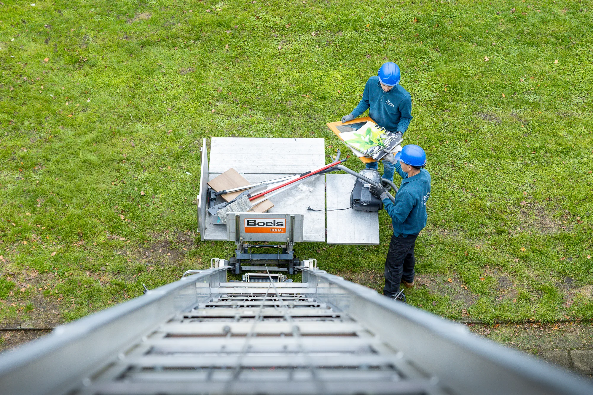 Twee medewerkers van De Circulaire Ontruimer laden spullen vanuit een woning in een verhuislift