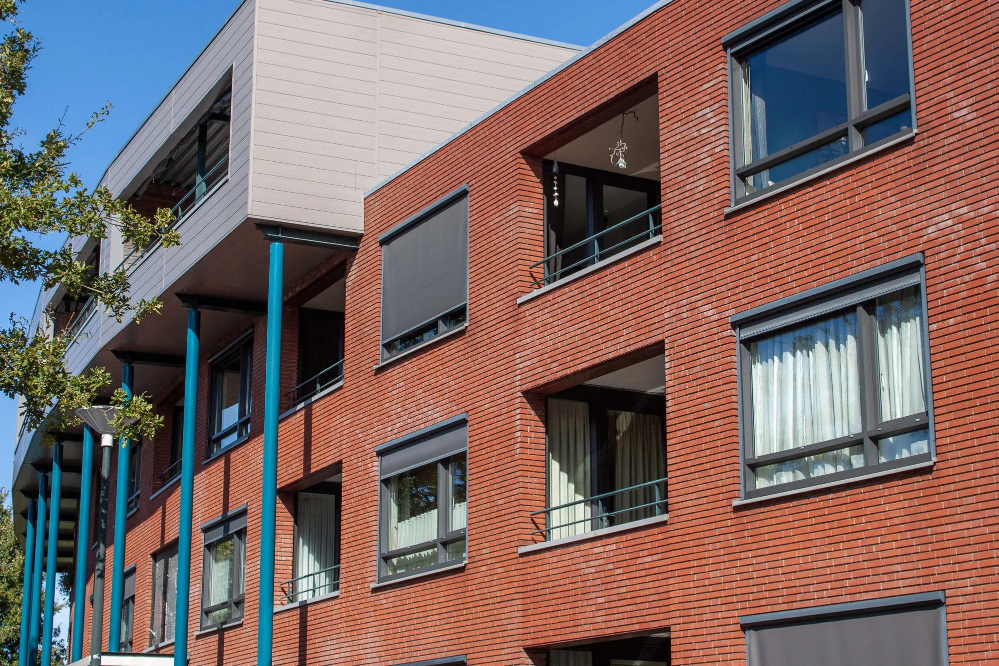 Buitengevel van een flatgebouw met balkons, zoals bij een huurwoning van een woningcorporatie