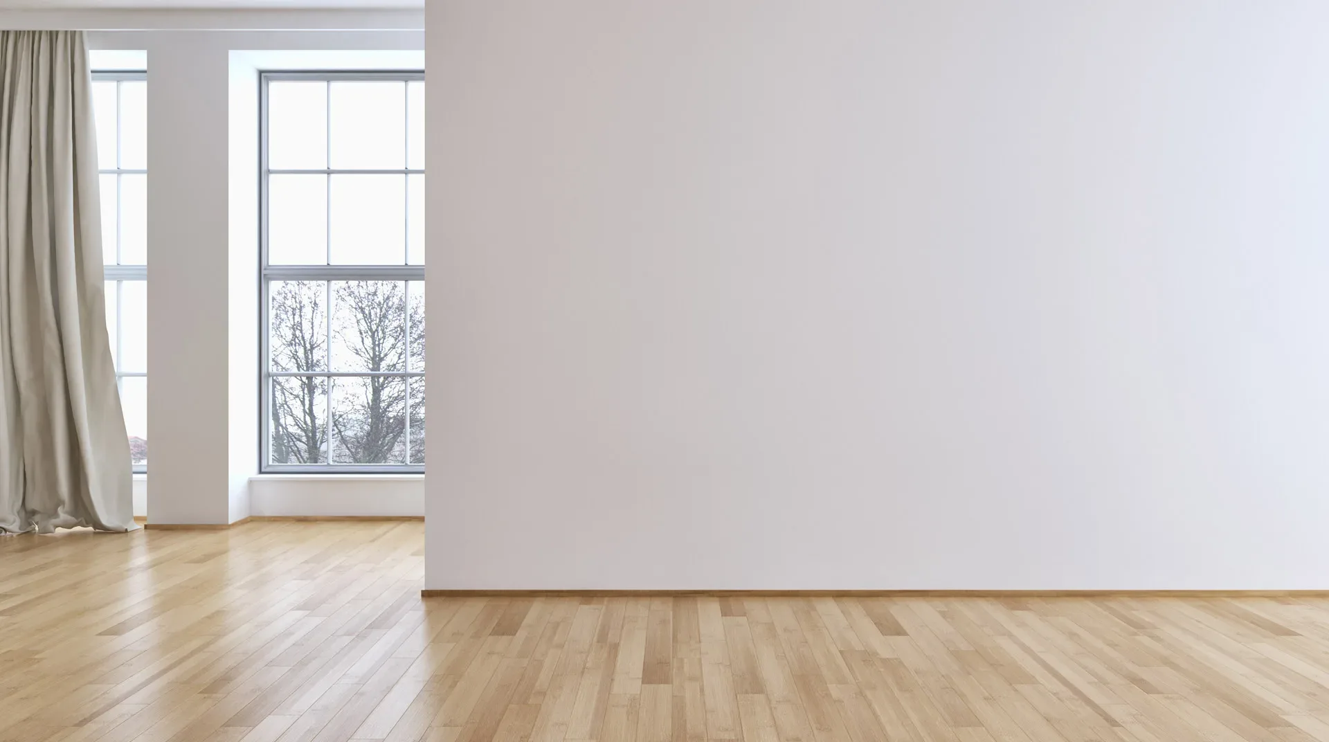 Lege, bezemschoon opgeleverde kamer met houten vloer en grote ramen