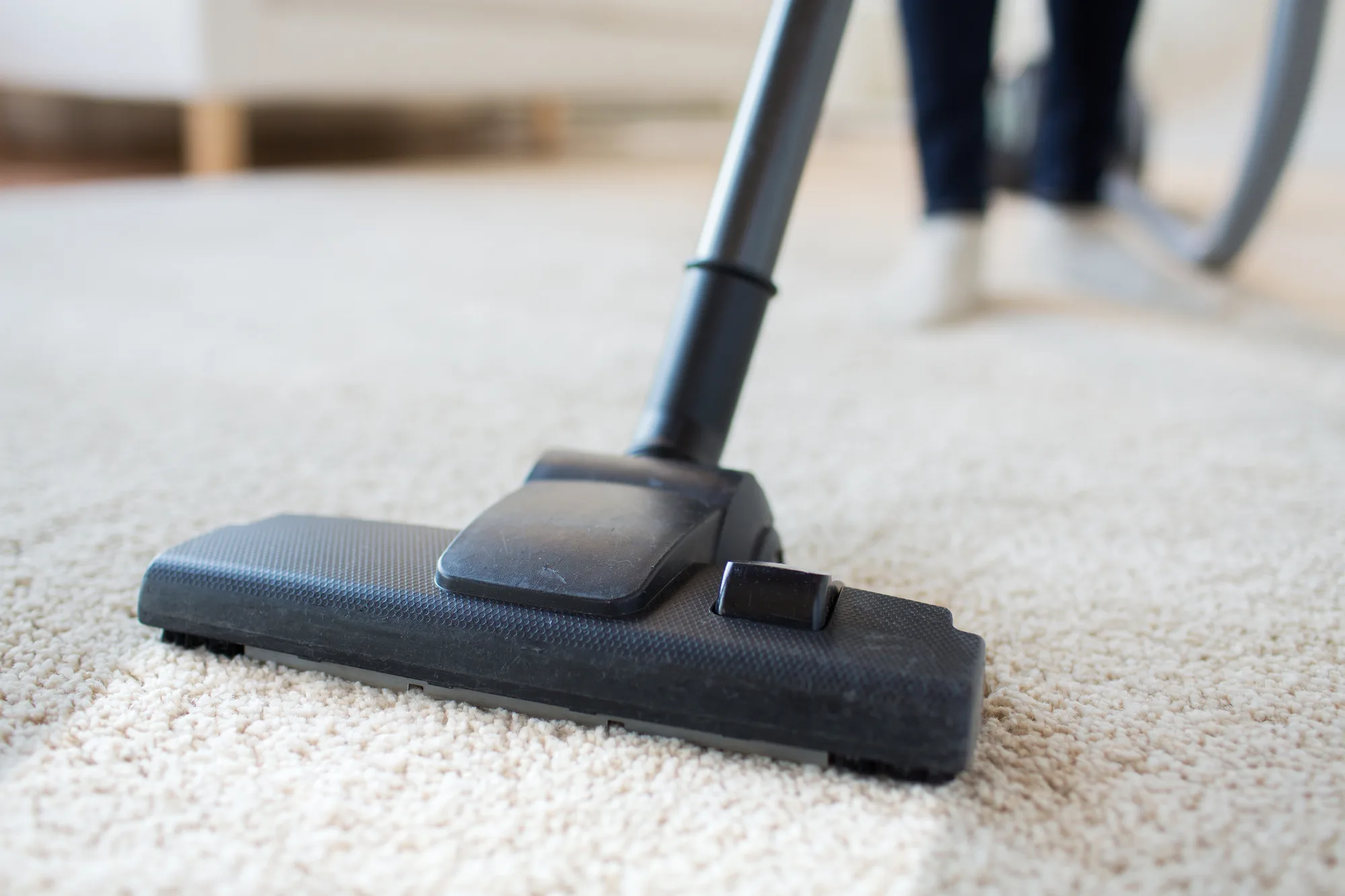 Stofzuiger die het tapijt schoonmaakt bij de laatste schoonmaakbeurt voor de oplevering
